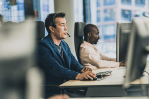 Deux hommes assis à des bureaux avec des ordinateurs